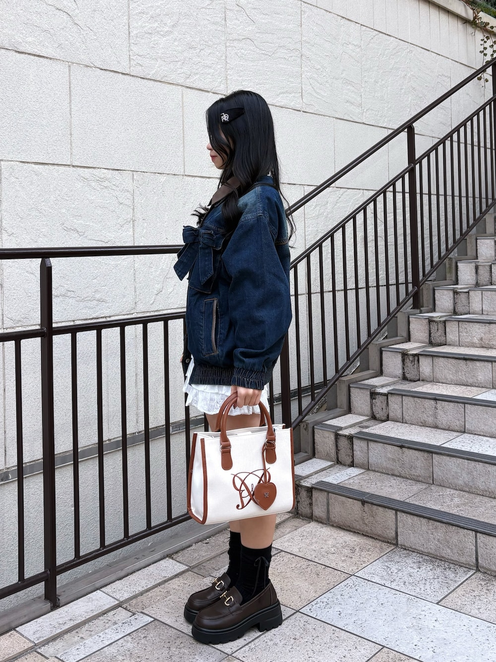 ブルー系のブルゾン、ブラウン系のトートバッグ、ホワイト系のスカートを着用したレディースの冬コーディネートの3枚目の写真
