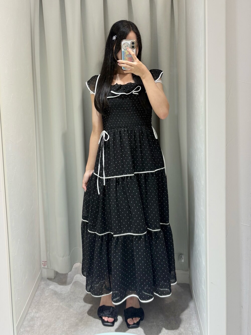 ブラック系のワンピース、ベージュ系のボストンバッグ、ブラック系のサンダルを着用したレディースの夏コーディネートの2枚目の写真