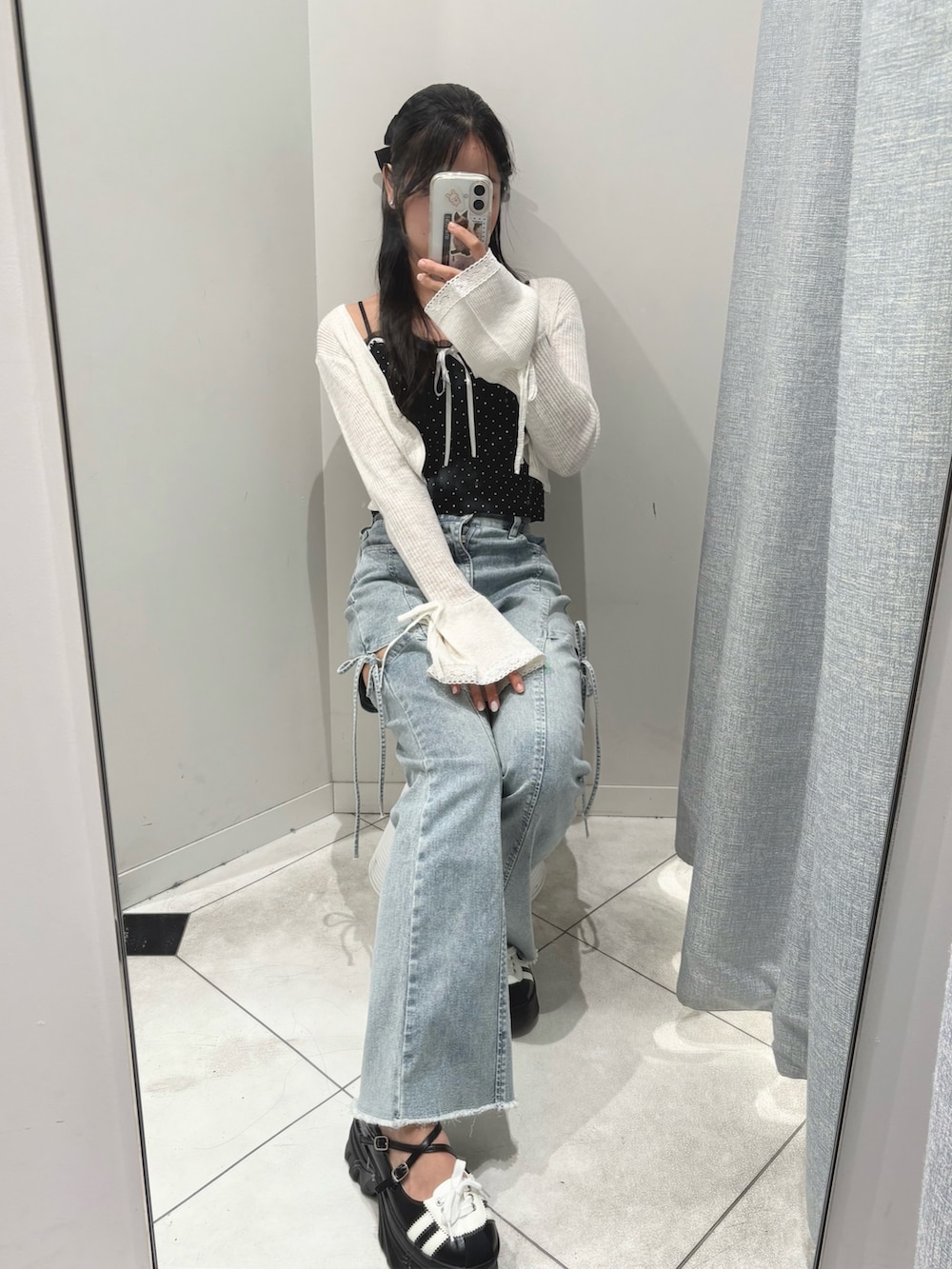 ブラック系のキャミソール、ホワイト系のカーディガン/ボレロ、ブルー系のデニムパンツを着用したレディースの夏コーディネートの2枚目の写真