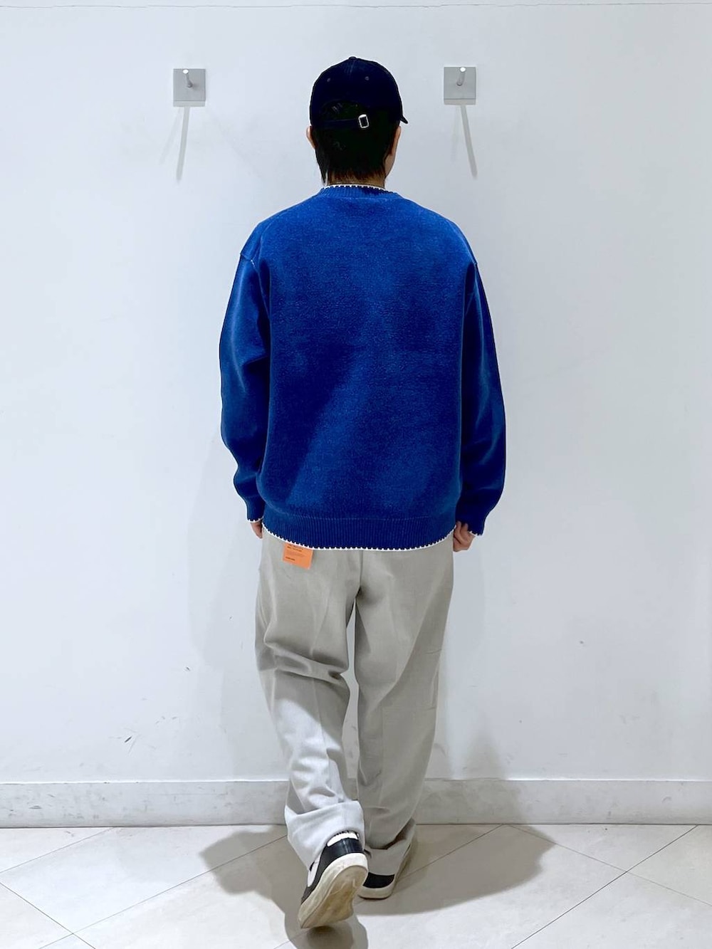 ベージュ系のその他パンツ、ブルー系のニット/セーター、ブルー系のキャップを着用したメンズの秋コーディネートの3枚目の写真