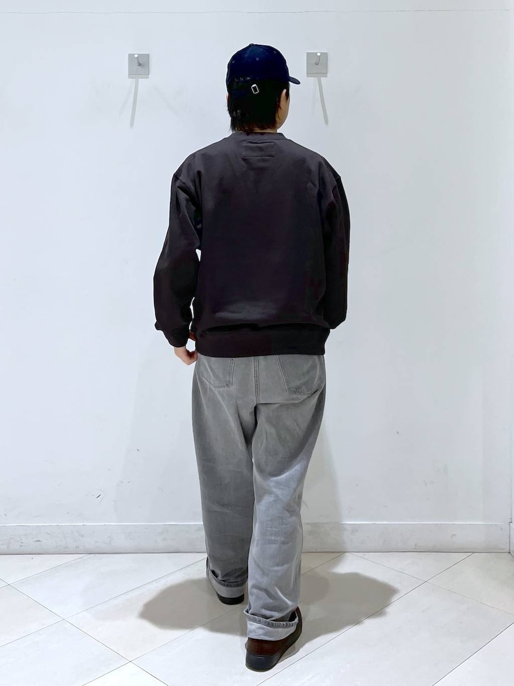 ブラウン系のその他シューズ、ブラウン系のTシャツ/カットソー、ブルー系のキャップを着用したメンズの秋コーディネートの4枚目の写真