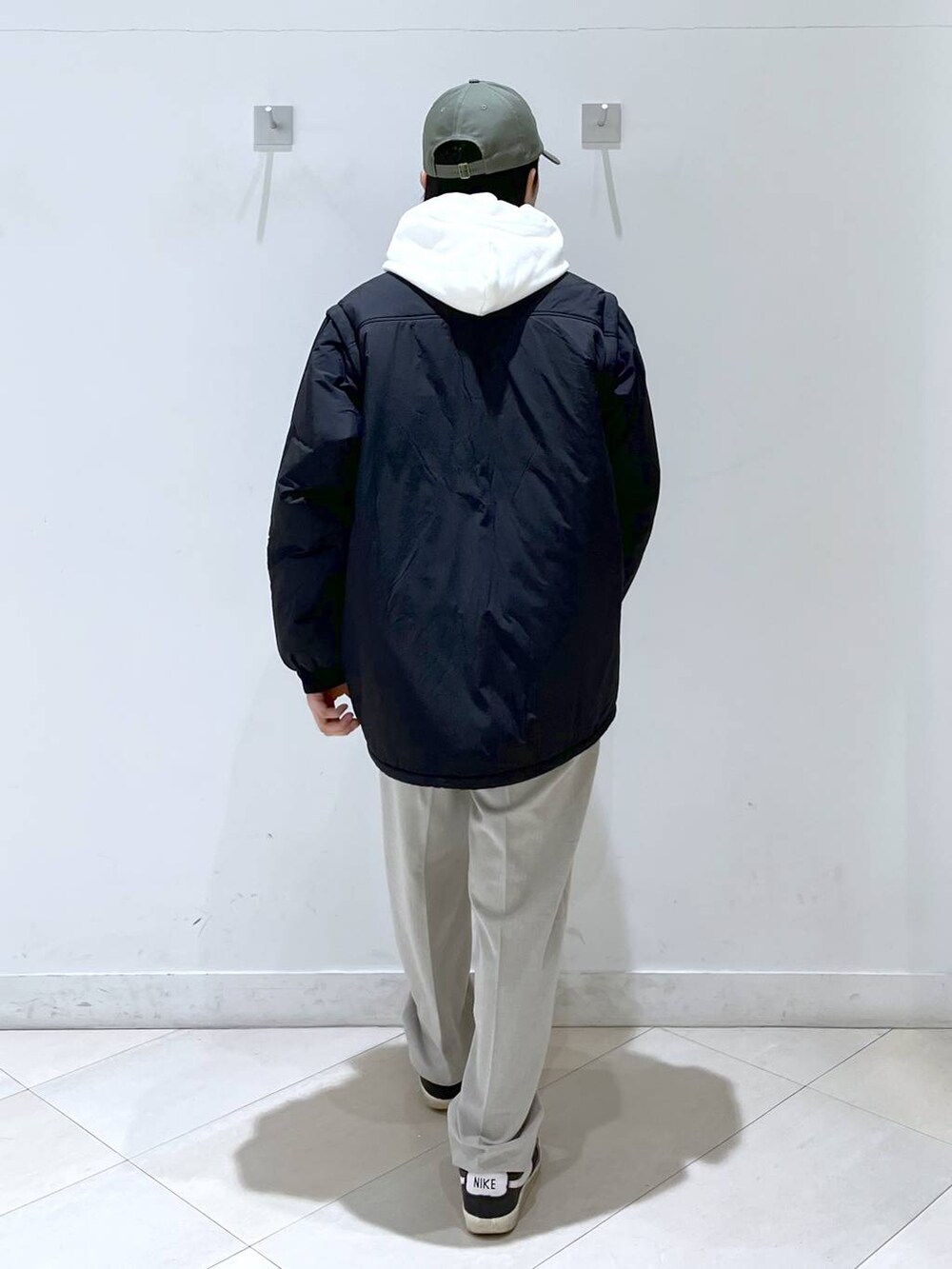 ブラック系のブルゾン、ベージュ系のその他パンツ、ホワイト系のパーカーを着用したメンズの冬コーディネートの3枚目の写真