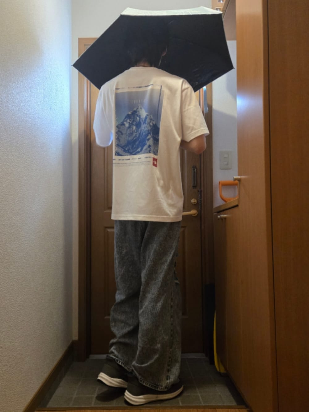 ホワイト系のTシャツ/カットソー、ブルー系のデニムパンツ、グレー系のスニーカーを着用したメンズの秋コーディネートの2枚目の写真