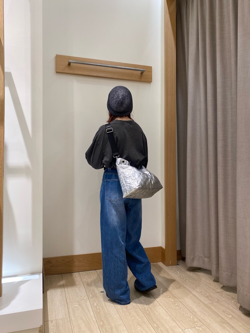 ブラック系のTシャツ/カットソー、ブルー系のデニムパンツ、シルバー系のショルダーバッグを着用したレディースの秋コーディネートの2枚目の写真