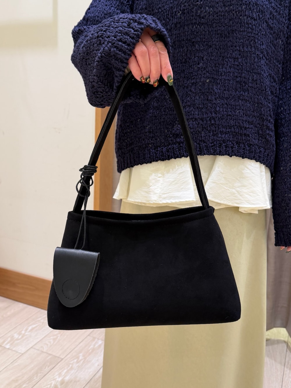 ブルー系のニット/セーター、ホワイト系のシャツ/ブラウス、グリーン系のスカートを着用したレディースの春コーディネートの4枚目の写真