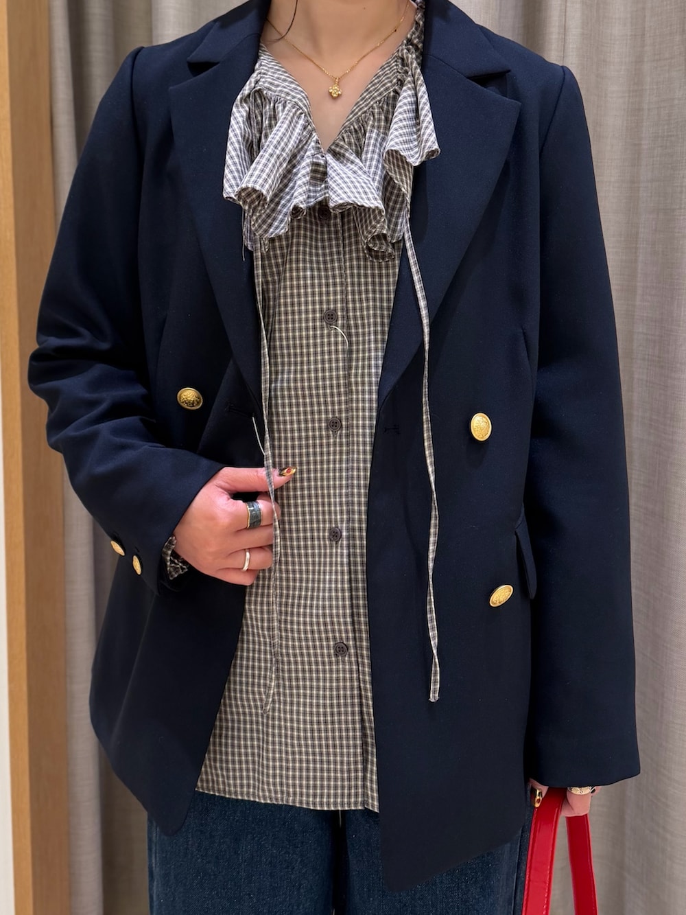 ブルー系のテーラードジャケット、ブラック系のシャツ/ブラウス、レッド系のショルダーバッグを着用したレディースの春コーディネートの2枚目の写真