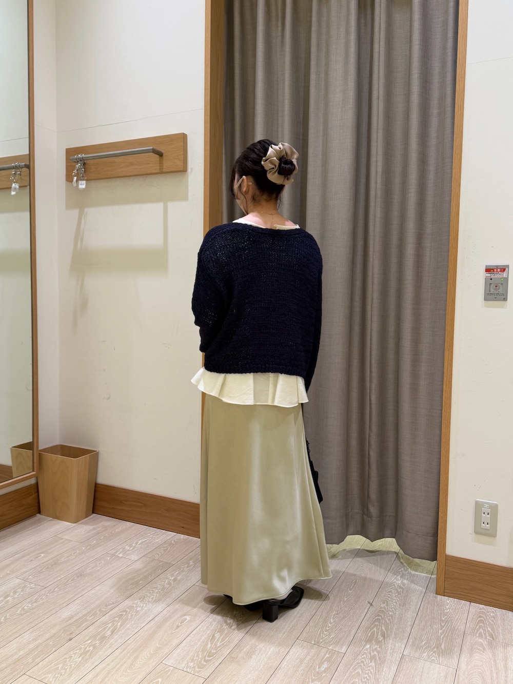 ブルー系のニット/セーター、ホワイト系のシャツ/ブラウス、グリーン系のスカートを着用したレディースの春コーディネートの2枚目の写真