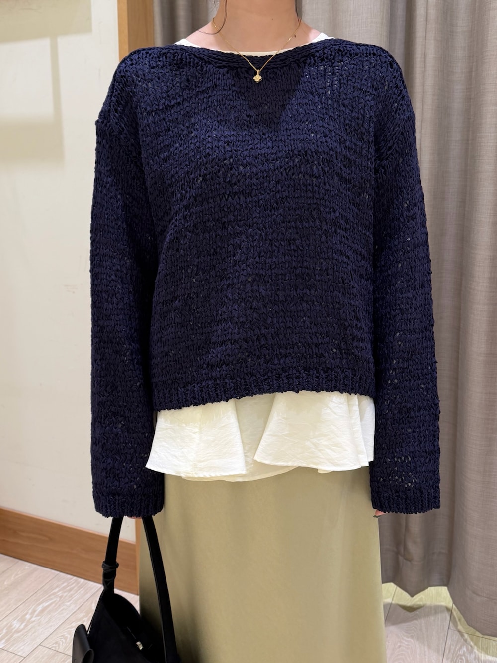 ブルー系のニット/セーター、ホワイト系のシャツ/ブラウス、グリーン系のスカートを着用したレディースの春コーディネートの3枚目の写真