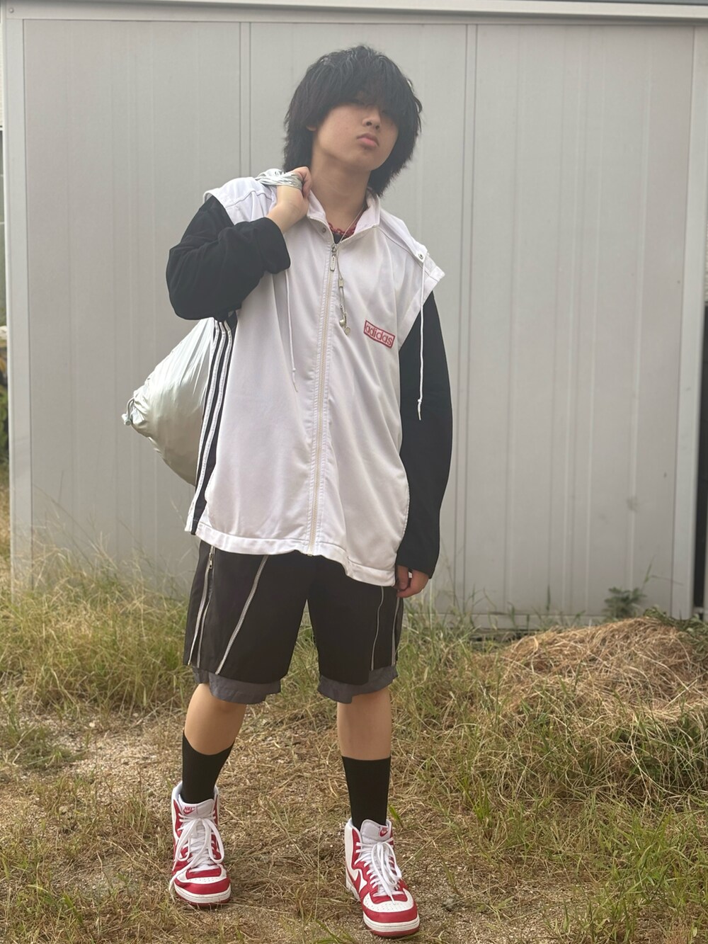 レッド系のスニーカー、シルバー系のショルダーバッグ、ブラック系のその他パンツを着用したメンズの夏コーディネートの2枚目の写真