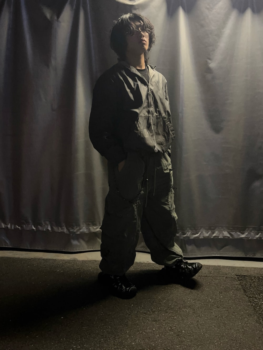 ブラック系のスニーカー、その他のカーゴパンツ、グレー系のマウンテンパーカーを着用したメンズの冬コーディネートの2枚目の写真