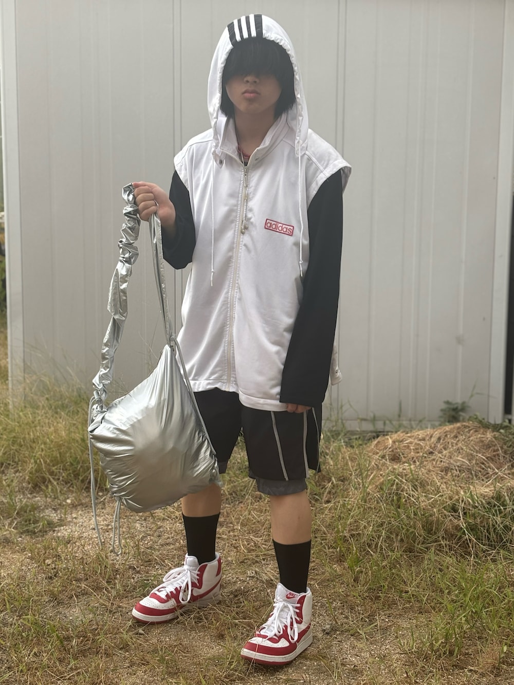 レッド系のスニーカー、シルバー系のショルダーバッグ、ブラック系のその他パンツを着用したメンズの夏コーディネートの3枚目の写真