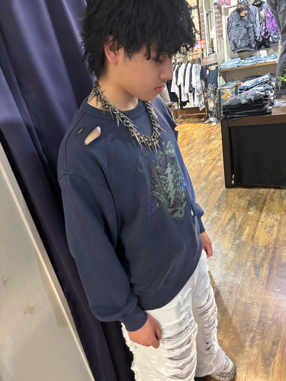 ブルー系のスウェット、ホワイト系のデニムパンツ、ブラック系のスニーカーを着用したメンズの春コーディネートの2枚目の写真