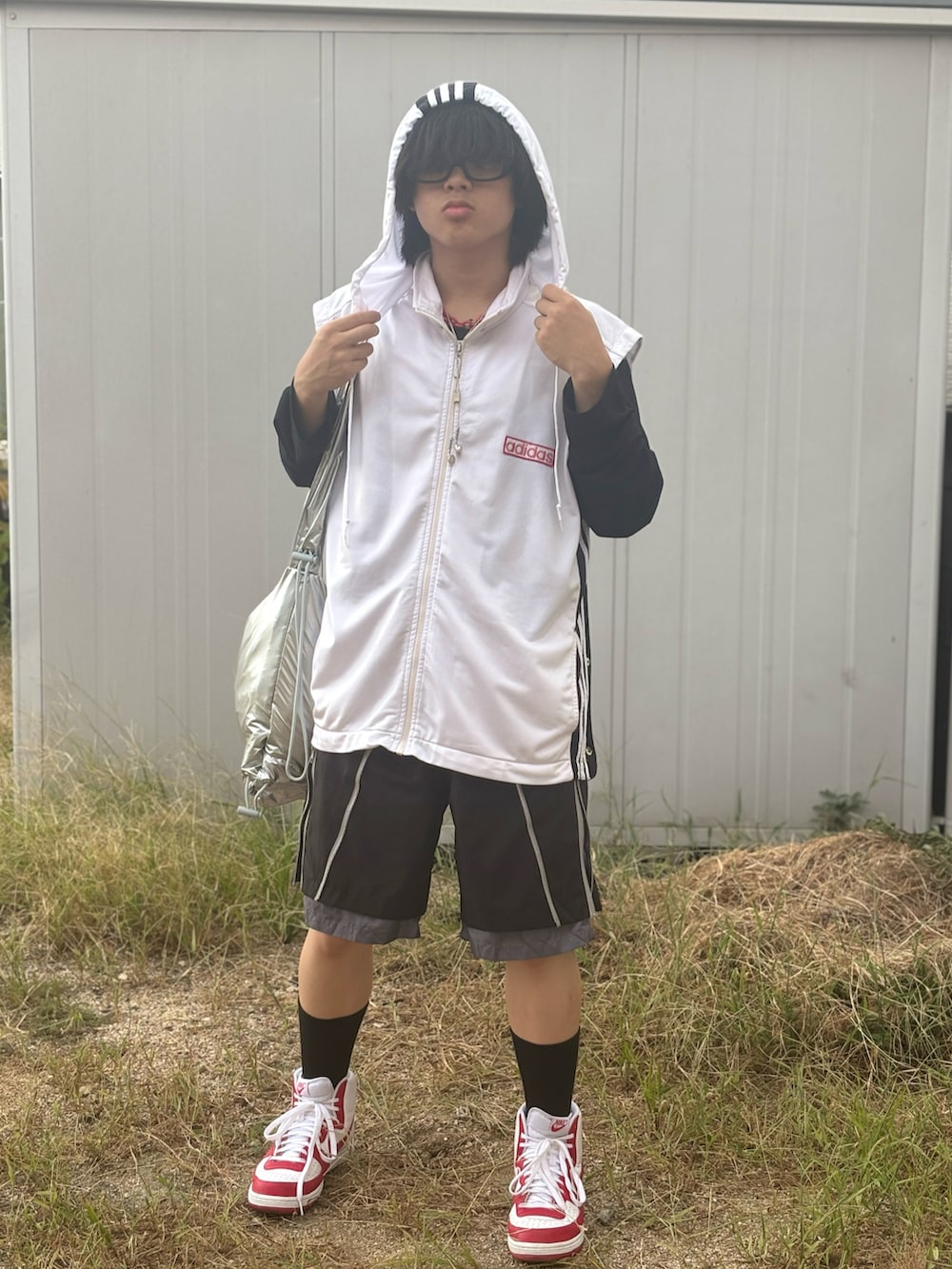 レッド系のスニーカー、シルバー系のショルダーバッグ、ブラック系のその他パンツを着用したメンズの夏コーディネートの4枚目の写真