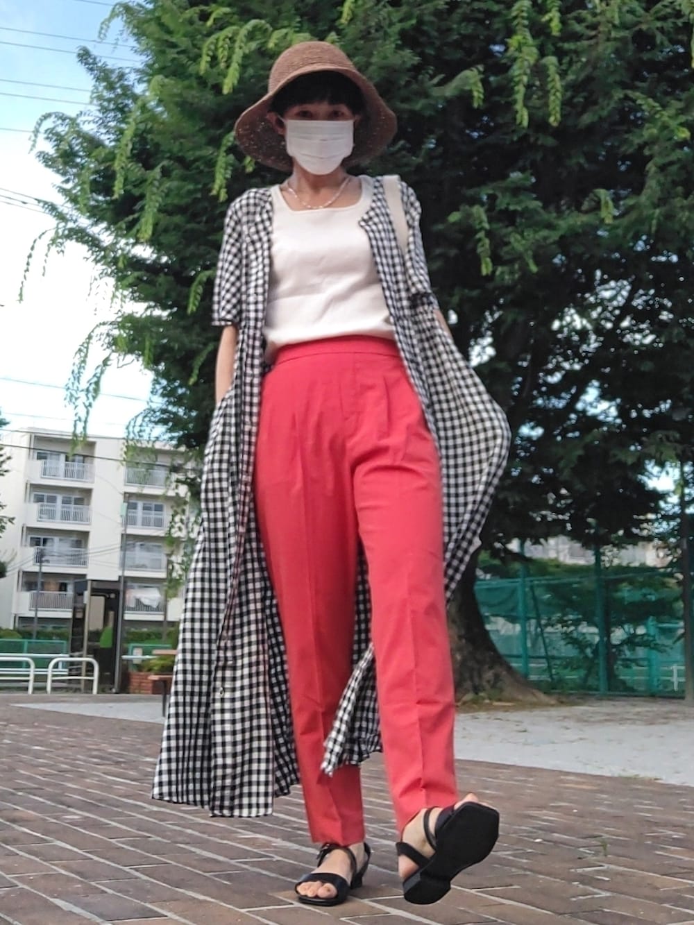 ホワイト系のクラッチバッグ、ホワイト系のタンクトップ、ブラック系のワンピースを着用したレディースの夏コーディネートの4枚目の写真