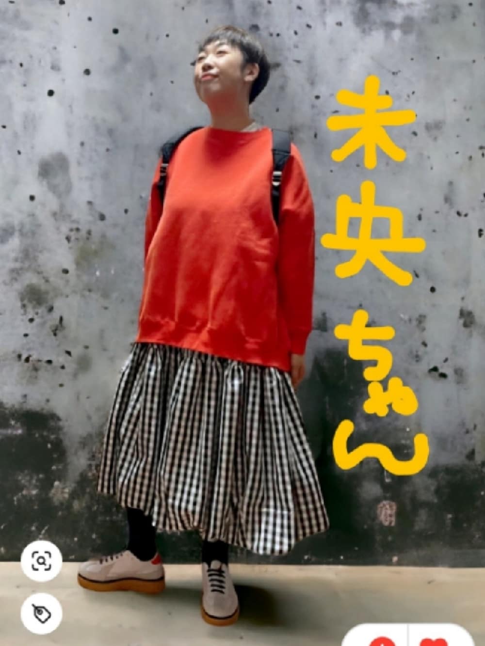 オレンジ系のカーディガン/ボレロ、ブラック系のスカート、ホワイト系のブーツを着用したレディースの秋コーディネートの2枚目の写真