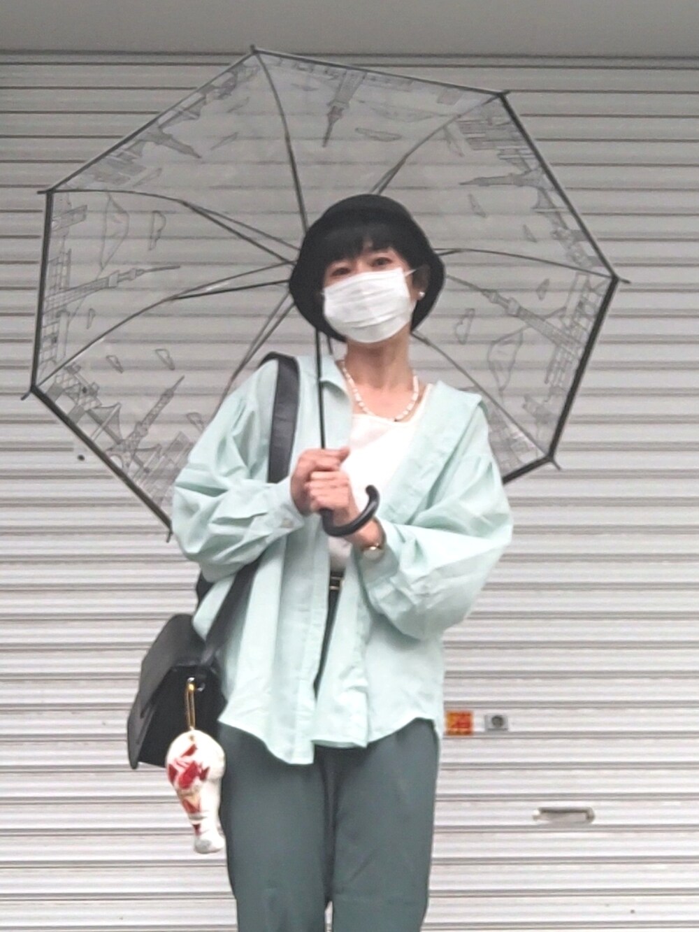 ホワイト系のタンクトップ、グリーン系のシャツ/ブラウス、グリーン系のスラックスを着用したレディースの夏コーディネートの2枚目の写真