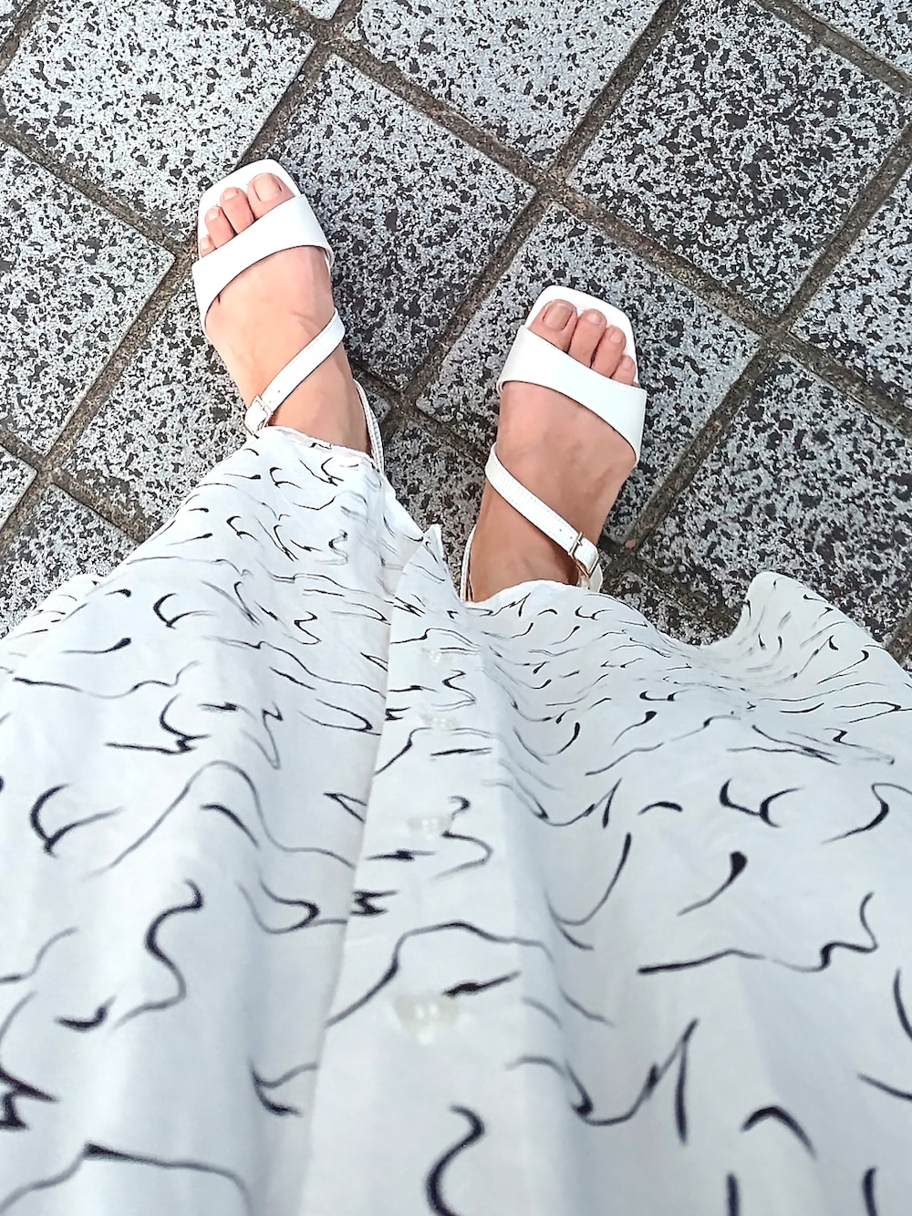 ホワイト系のワンピース、ホワイト系のサンダル、ベージュ系のハットを着用したレディースの夏コーディネートの2枚目の写真