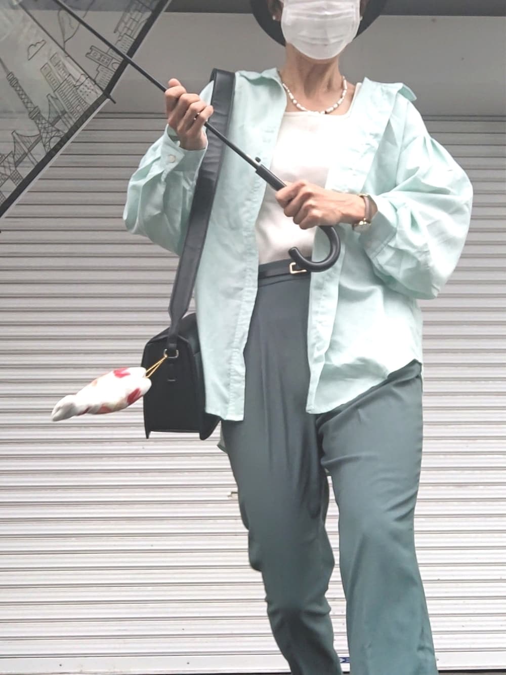 ホワイト系のタンクトップ、グリーン系のシャツ/ブラウス、グリーン系のスラックスを着用したレディースの夏コーディネートの3枚目の写真