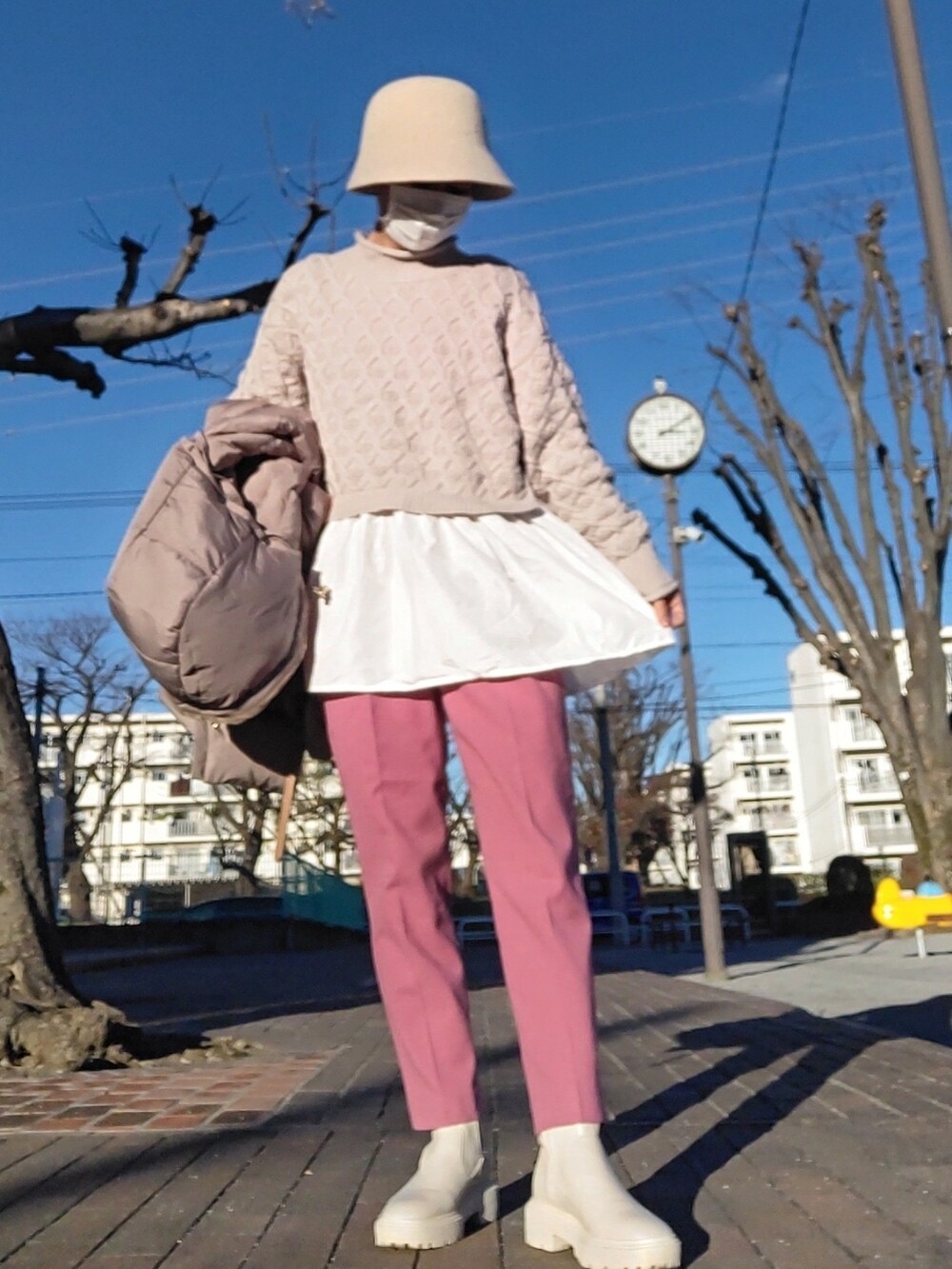 ブラウン系のダウンジャケット/コート、グレー系のニット/セーター、ピンク系のその他パンツを着用したレディースの冬コーディネートの2枚目の写真