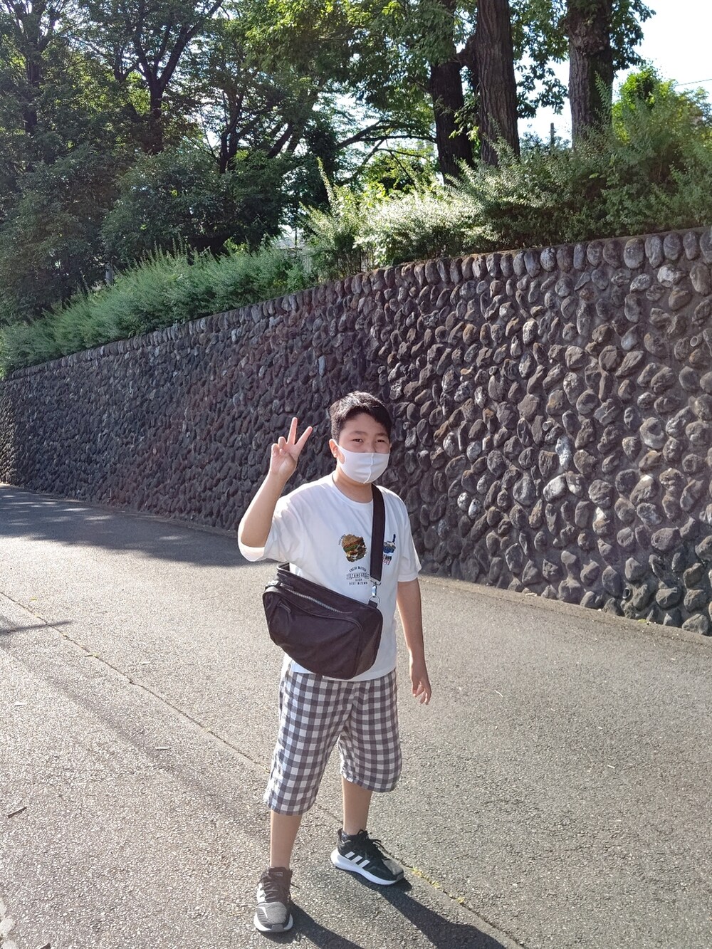 ホワイト系のTシャツ/カットソー、ブルー系のデニムパンツ、ホワイト系のサンダルを着用したレディースの夏コーディネートの2枚目の写真