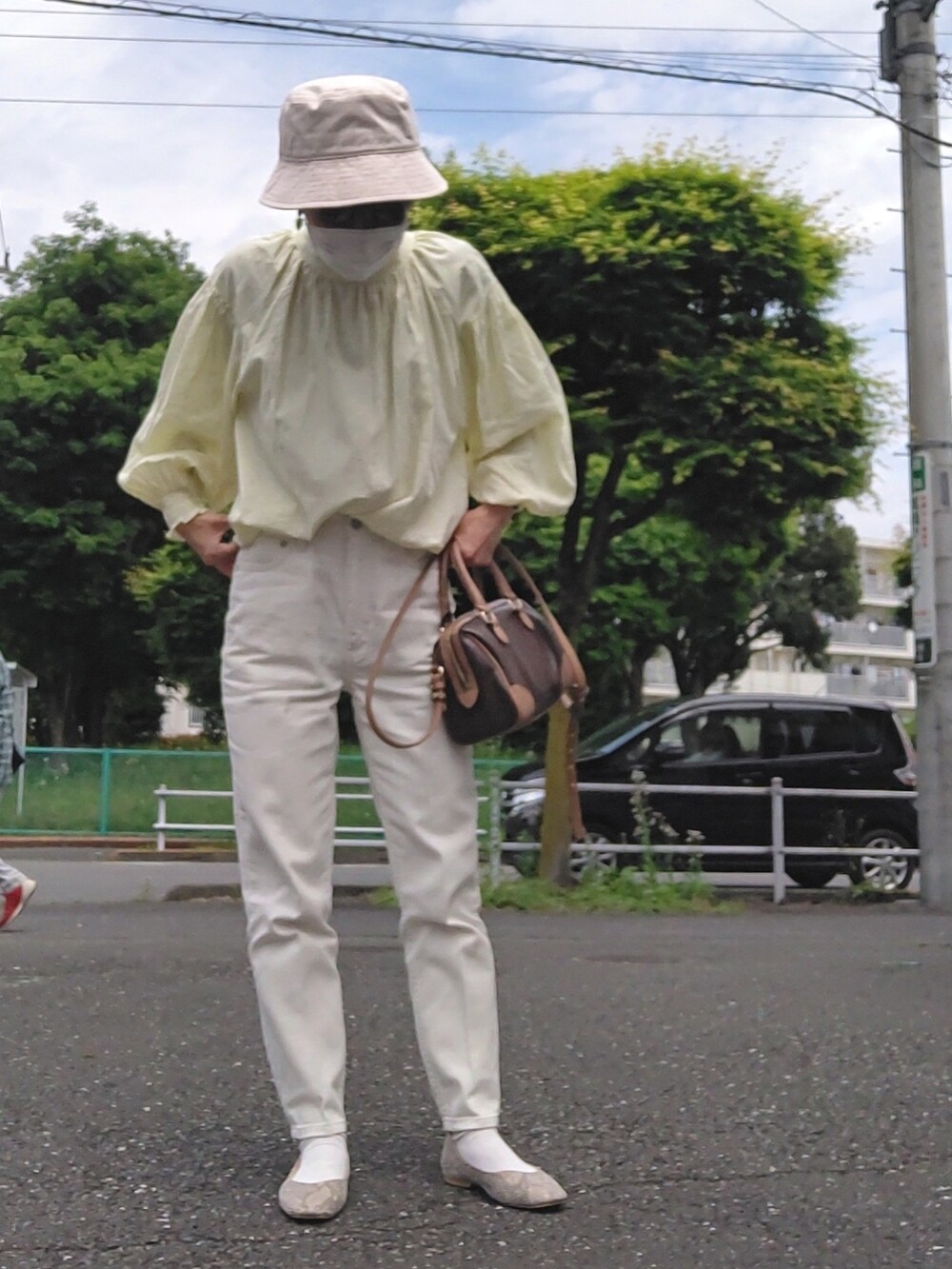 イエロー系のシャツ/ブラウス、ホワイト系のデニムパンツ、ブラック系のパンプスを着用したレディースの春コーディネートの2枚目の写真