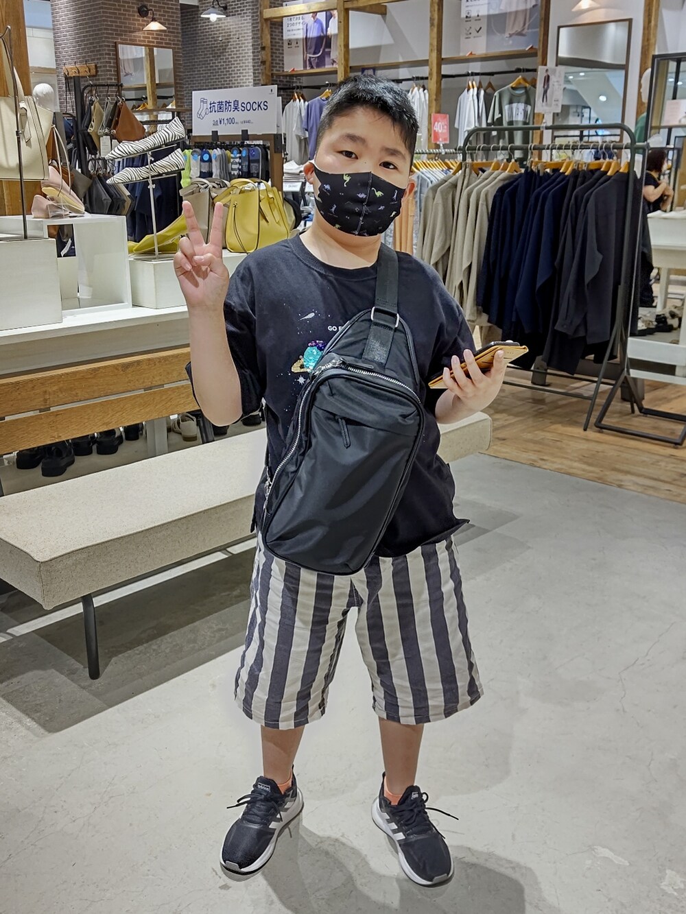 ブラック系のTシャツ/カットソー、ホワイト系のその他パンツ、ブラック系のショルダーバッグを着用したレディースの春コーディネートの2枚目の写真