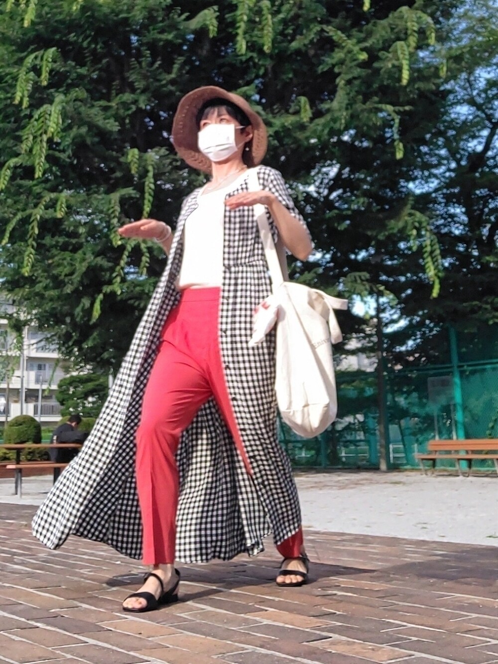 ホワイト系のクラッチバッグ、ホワイト系のタンクトップ、ブラック系のワンピースを着用したレディースの夏コーディネートの2枚目の写真