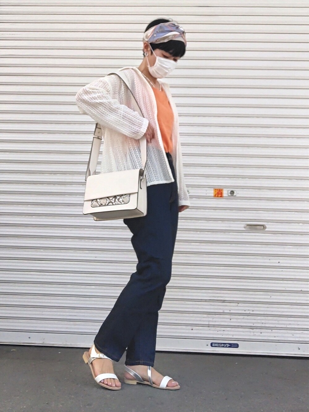 オレンジ系のタンクトップ、ホワイト系のシャツ/ブラウス、ブルー系のデニムパンツを着用したレディースの夏コーディネートの2枚目の写真