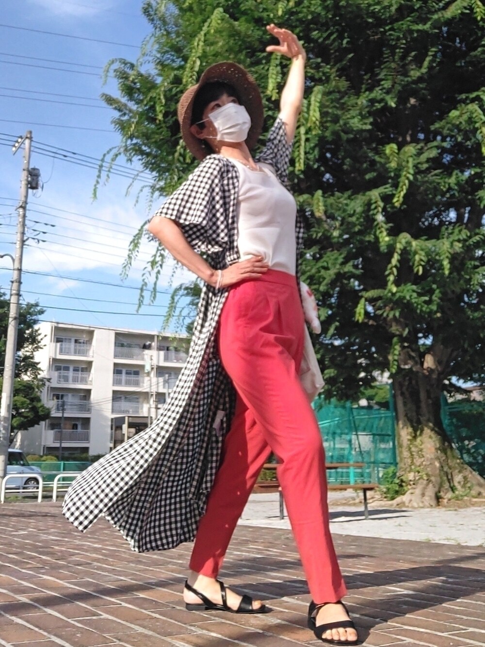 ホワイト系のクラッチバッグ、ホワイト系のタンクトップ、ブラック系のワンピースを着用したレディースの夏コーディネートの3枚目の写真