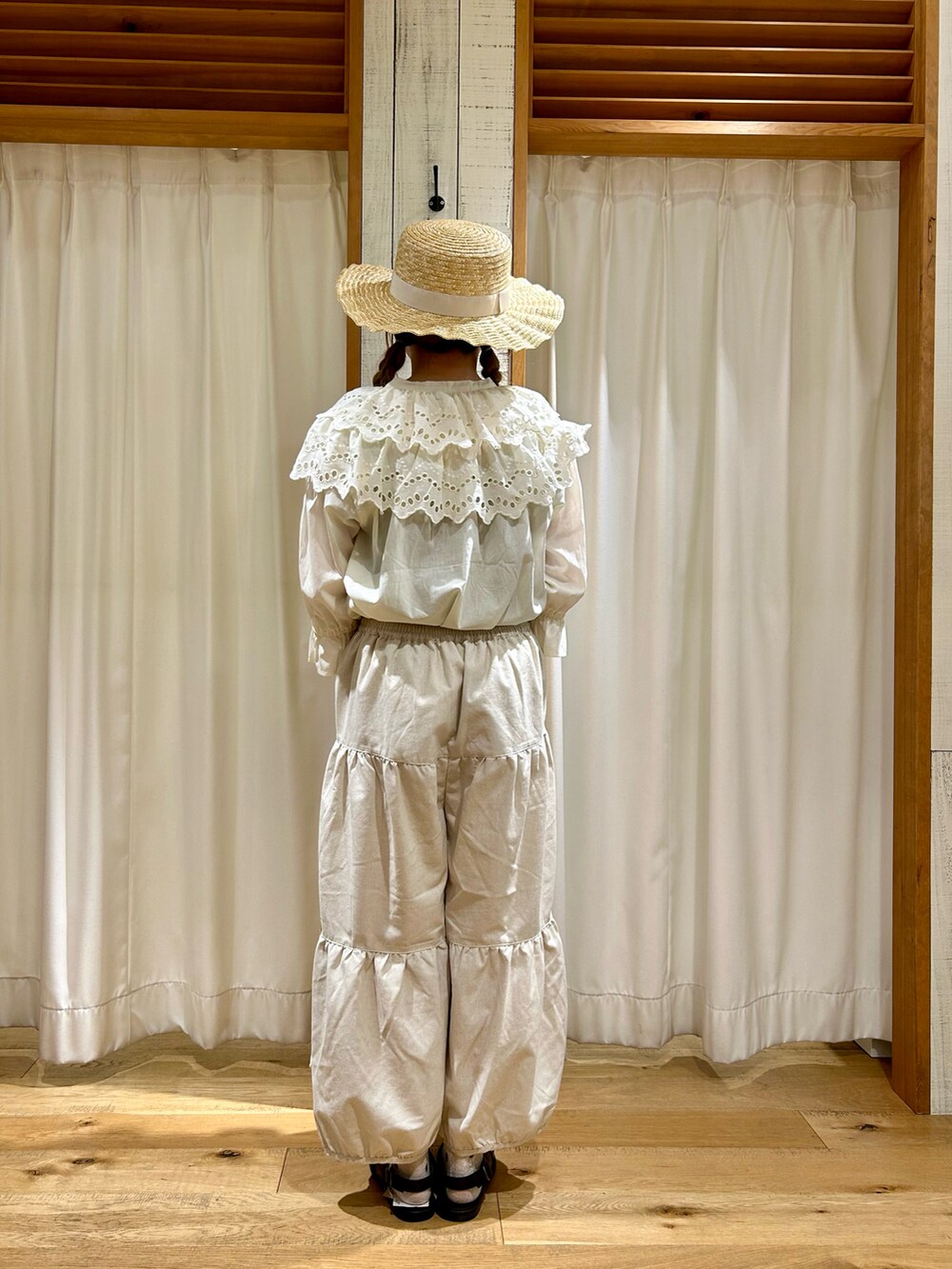 ホワイト系のパンツ、ホワイト系のハットを着用したレディースの夏コーディネートの3枚目の写真