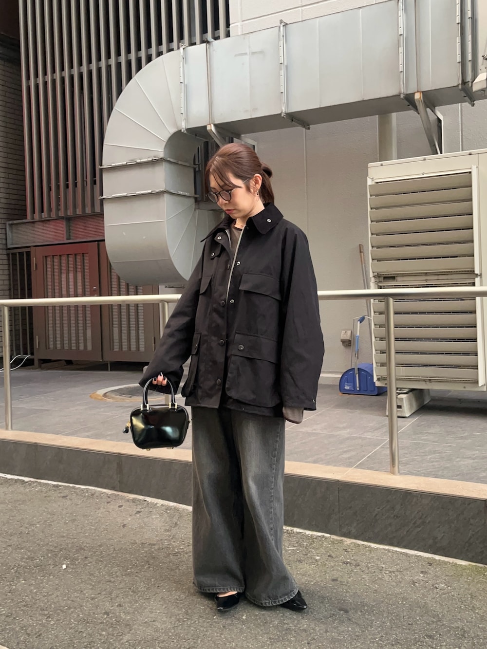 ブラック系のデニムパンツ、ブラック系のパンプス、グレー系のTシャツ/カットソーを着用したレディースの秋コーディネートの2枚目の写真