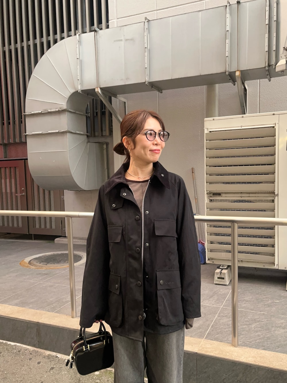 ブラック系のデニムパンツ、ブラック系のパンプス、グレー系のTシャツ/カットソーを着用したレディースの秋コーディネートの4枚目の写真