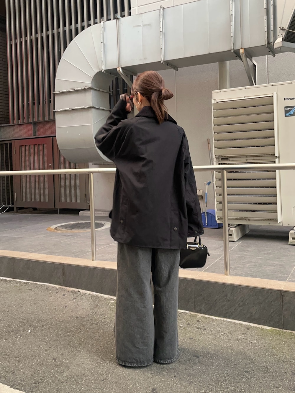 ブラック系のデニムパンツ、ブラック系のパンプス、グレー系のTシャツ/カットソーを着用したレディースの秋コーディネートの3枚目の写真