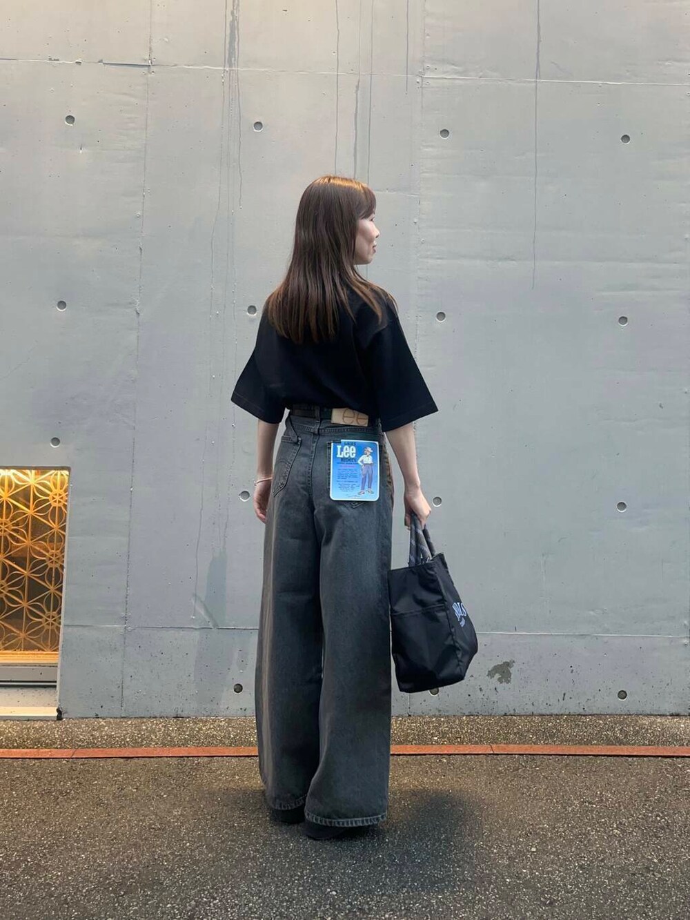 ブラック系のサンダル、ブラック系のデニムパンツ、ブラック系のTシャツ/カットソーを着用したレディースの夏コーディネートの3枚目の写真