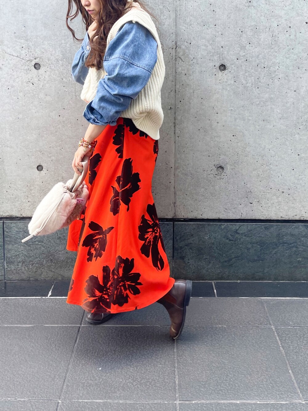 オレンジ系のスカートを着用したレディースの冬コーディネートの3枚目の写真