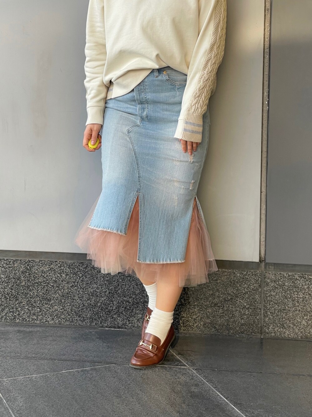 ブルー系のデニムスカートを着用したレディースの冬コーディネートの2枚目の写真