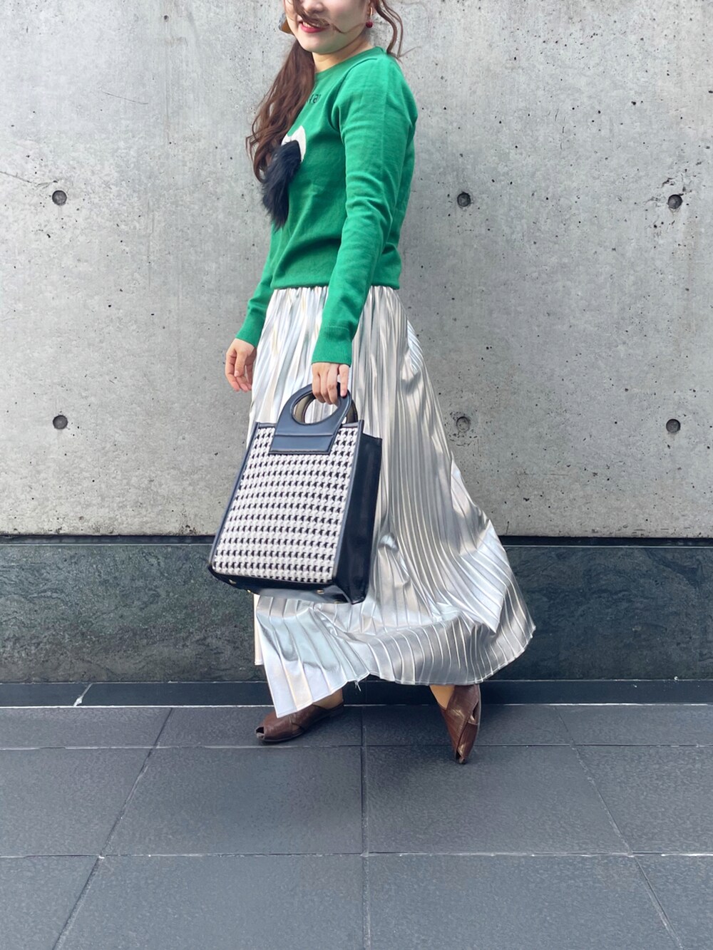 シルバー系のスカートを着用したレディースの秋コーディネートの2枚目の写真