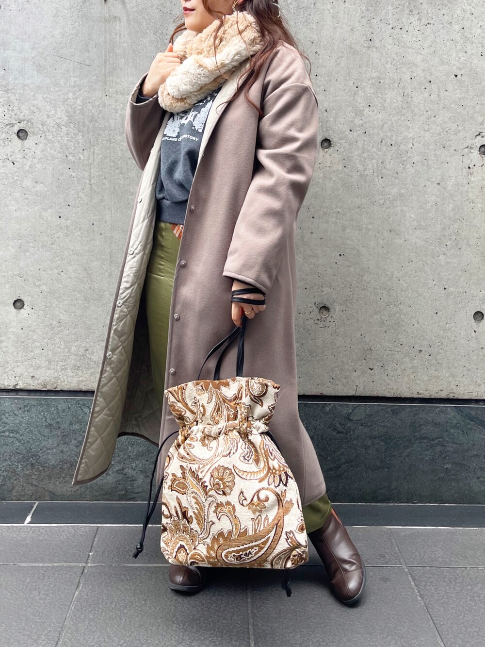 ベージュ系のバッグを着用したレディースの冬コーディネートの2枚目の写真
