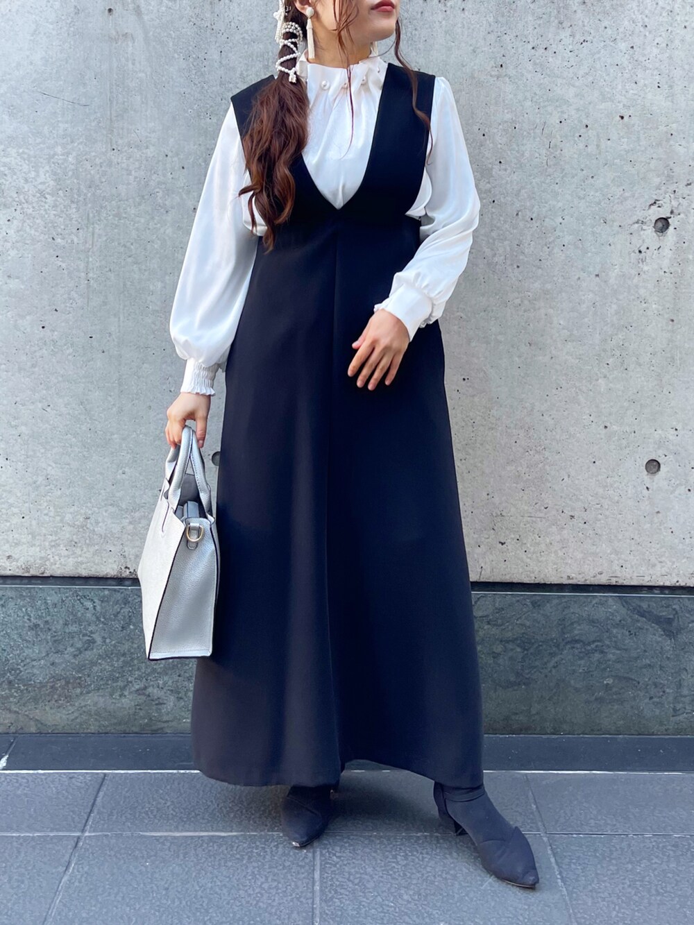 ブラック系のトートバッグを着用したレディースの冬コーディネートの2枚目の写真