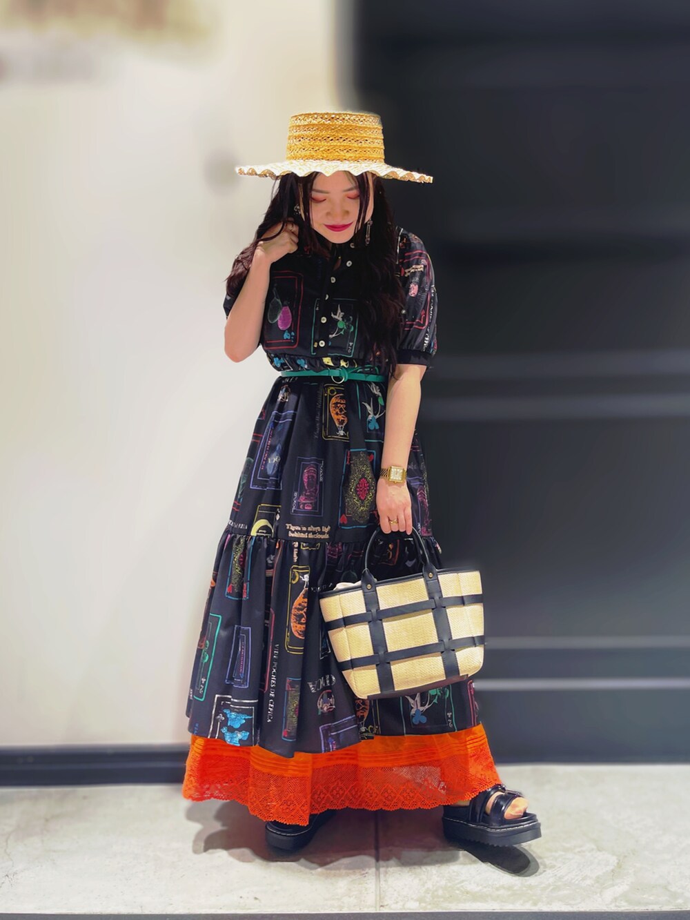 ブラック系のサンダル、ホワイト系のスカート、ブラック系のハットを着用したレディースの春コーディネートの2枚目の写真