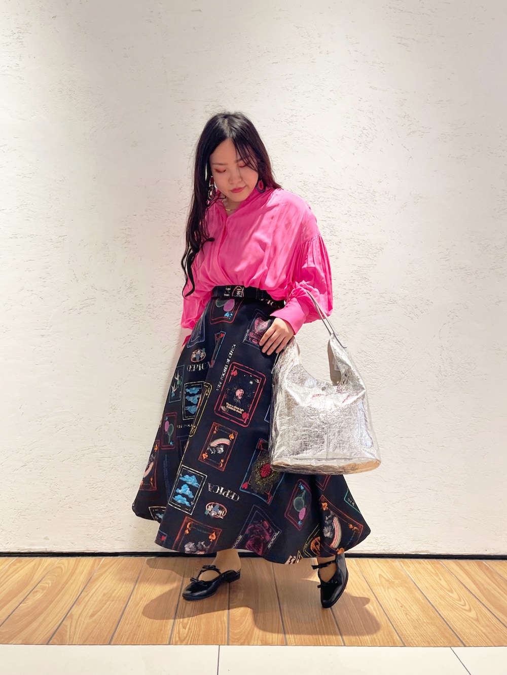 ホワイト系のスカート、ブラック系のサンダルを着用したレディースの春コーディネートの2枚目の写真