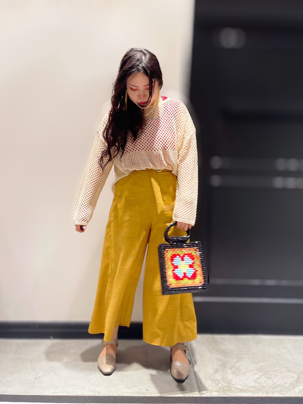 ベージュ系のドレスシューズ、ブラック系のハンドバッグを着用したレディースの春コーディネートの2枚目の写真