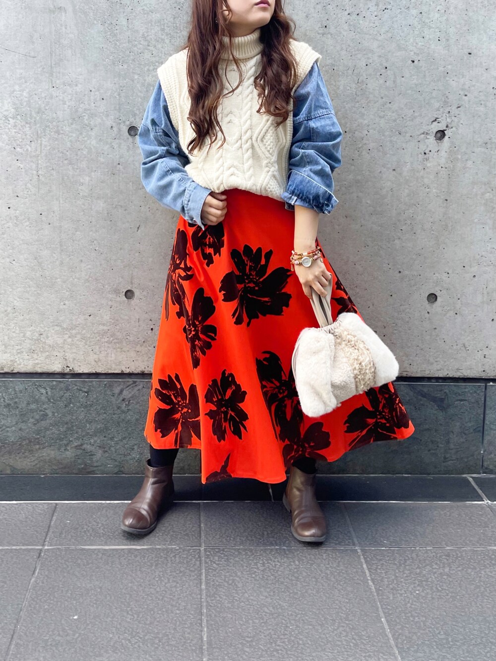 オレンジ系のスカートを着用したレディースの冬コーディネートの2枚目の写真