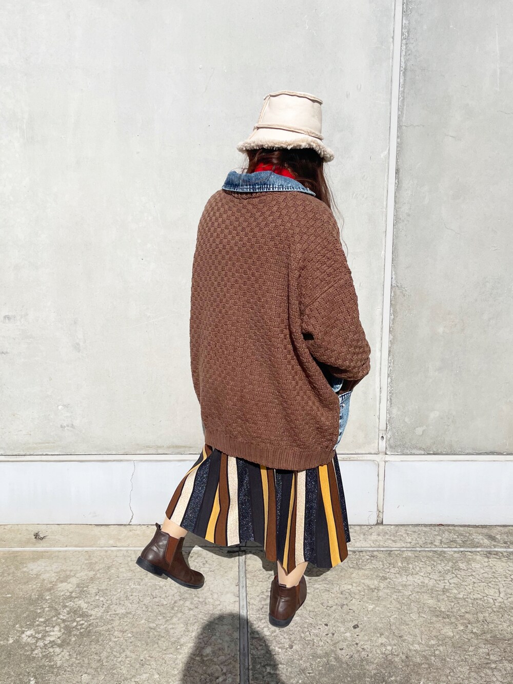 ブラウン系のスカート、ベージュ系の帽子を着用したレディースの秋コーディネートの3枚目の写真