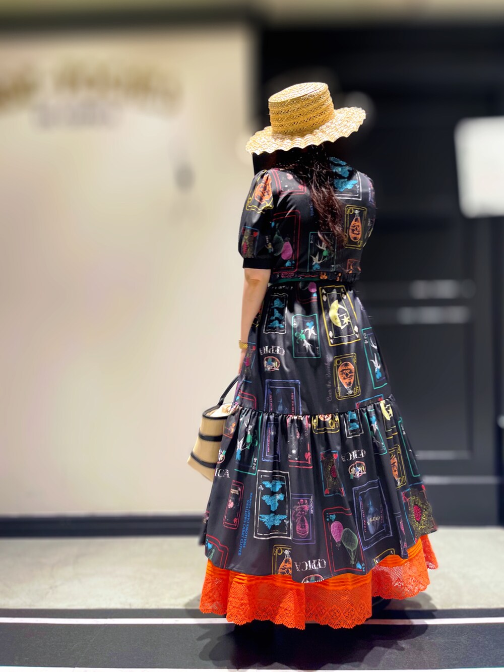 ブラック系のサンダル、ホワイト系のスカート、ブラック系のハットを着用したレディースの春コーディネートの3枚目の写真