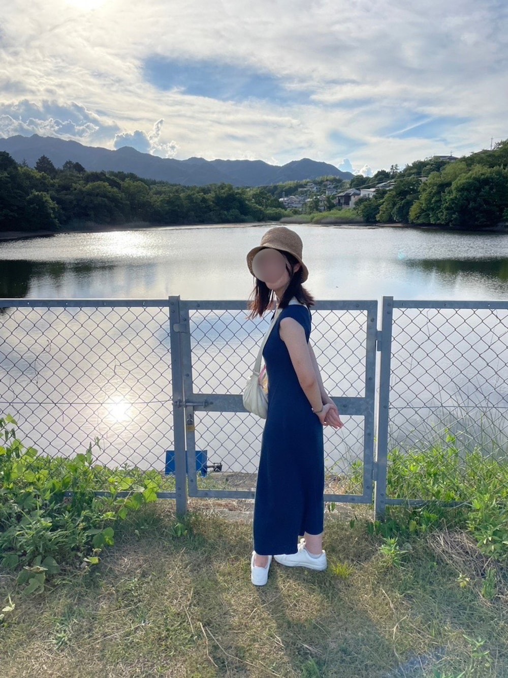 ブルー系のワンピース、ホワイト系のショルダーバッグ、ホワイト系のスニーカーを着用したレディースの秋コーディネートの2枚目の写真