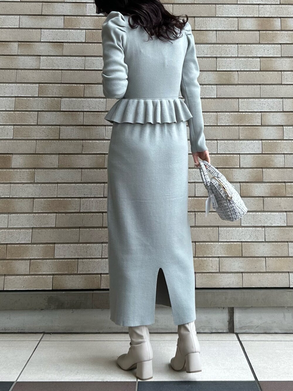 グリーン系のワンピース、ホワイト系のショルダーバッグ、ホワイト系のブーツを着用したレディースの冬コーディネートの2枚目の写真