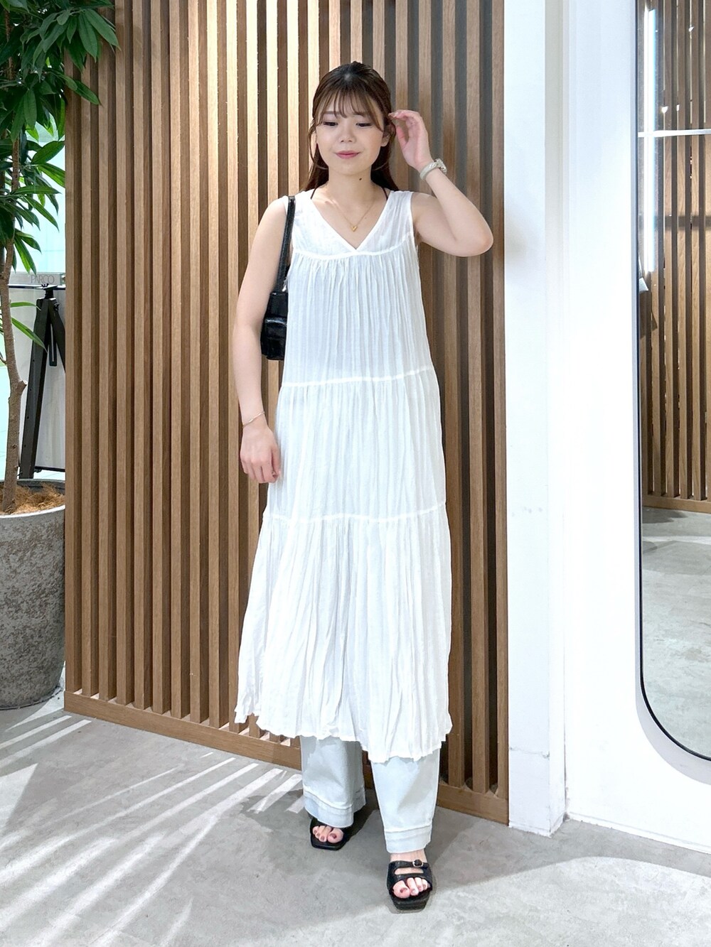 ホワイト系のワンピース、ブラック系のキャミソール、ブラック系のハンドバッグを着用したレディースの夏コーディネートの7枚目の写真