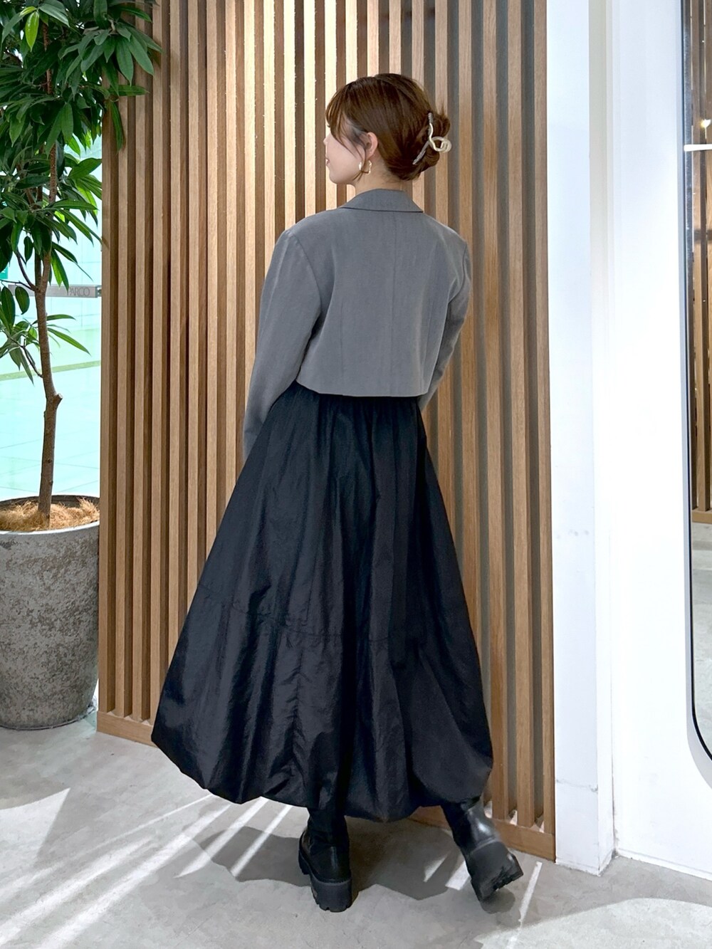 ホワイト系のTシャツ/カットソー、グレー系のテーラードジャケット、ブラック系のスカートを着用したレディースの秋コーディネートの4枚目の写真