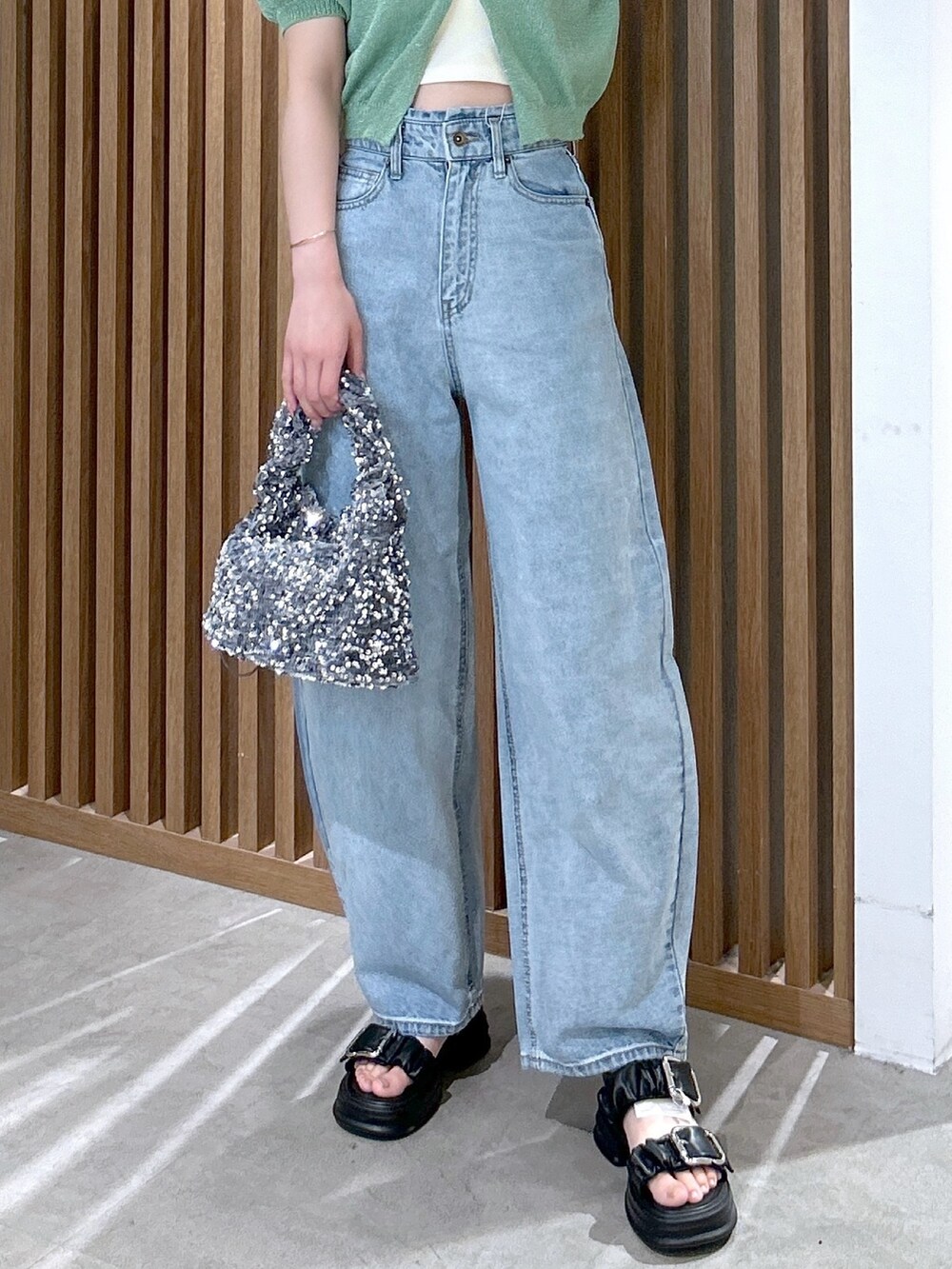 グリーン系のカーディガン/ボレロ、ホワイト系のキャミソール、ブルー系のデニムパンツを着用したレディースの春コーディネートの6枚目の写真